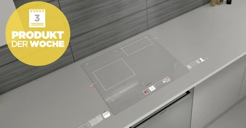 Ein Herd mit zwei rechteckigen Heizplatten steht in einer modernen Küche. Ein gelber Kreis mit der Aufschrift PRODUKT DER WOCHE 3 ist im linken oberen Bereich sichtbar.