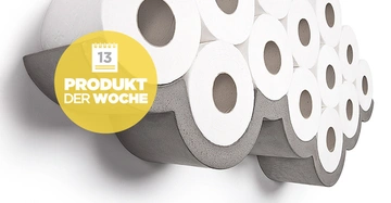 Ein wandmontiertes Regal hält mehrere Rollen Toilettenpapier zusammen in Form einer Wolke. Gelber runder Aufkleber mit Text: 13 Produkt der Woche.