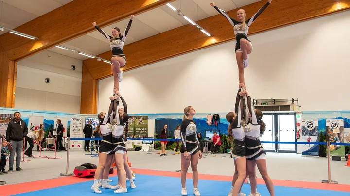 Galerie-Bild 5: Gruppe von Cheerleadern in blau-weißen Uniformen zeigt Hebefiguren.