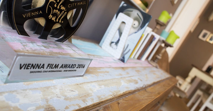 Galerie-Bild 7: Trophäe steht auf hölzerner Oberfläche in einem dekorativen Raum Text: VIENNA FILM AWARD 2016 SHOOTING-STAR INTERNATIONAL - PETER WINDHOFER