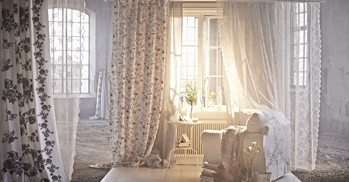 Galerie-Bild 2: Vorhänge hängen an einer Stange vor einem Fenster. Ein Sessel mit Decke und Buchstapel steht daneben. Sonnenlicht durchflutet den Raum, der wie ein verlassenes Gebäude wirkt.