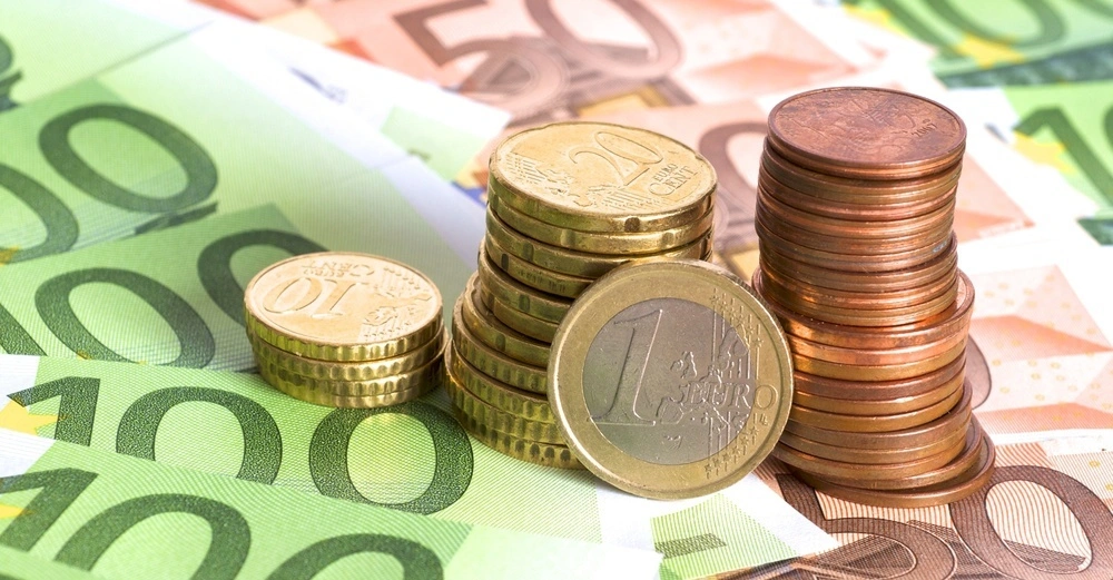Euromünzen und Einhundert, sowie Fünzig-Euro-Scheine liegen auf einem Tisch.