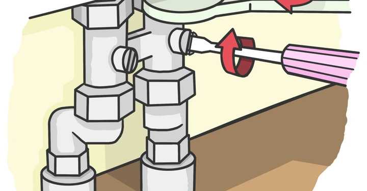 Schraubenschlüssel drehen Rohrverbindung in einer Wand-installation während ein Schraubenzieher eine Schraube dreht auf einer Holzbodenoberfläche im Hintergrund.