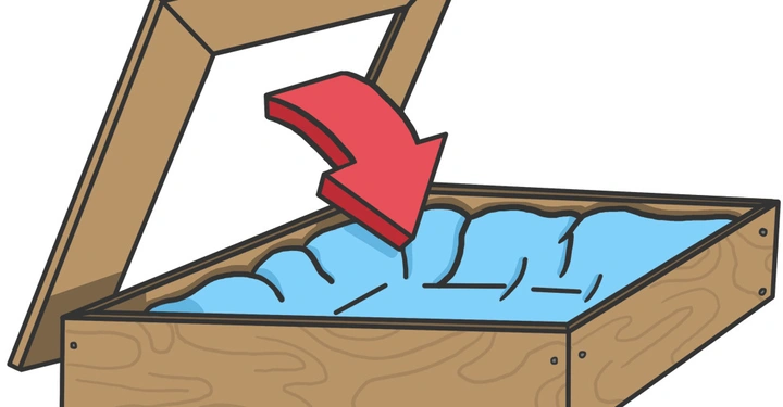 Ein hölzerner Rahmen kippt eine weiche blaue Matratze aus seinem Inneren auf den Boden