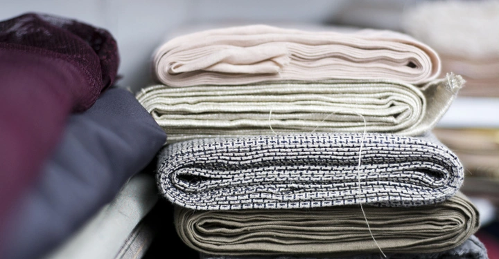 Galerie-Bild 2: Stapel gefalteter Stoffe in verschiedenen Farben liegen auf einem Tisch in einem Textilgeschäft חמ