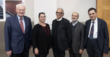 4 ältere Herren und eine jüngere Frau, alle in schwarzem Anzug oder schwarzen Outfits gekleidet, lächeln freundlich in die Kamera. Eröffnung der Ausstellung Bauherrenpreis