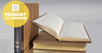 Ein offenes Tagebuch liegt auf einem Stapel Bücher daneben steht ein geschlossenes Buch in einem hellen Raum Text im Bild: 12 PRODUKT DER WOCHE 2017-2026