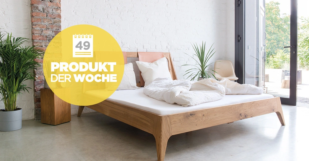 Holzbett Steht in einem modern eingerichteten Schlafzimmer weiße Wände Pflanze im Topf links Stuhl daneben große Fenster Text im Bild: 49 PRODUKT DER WOCHE