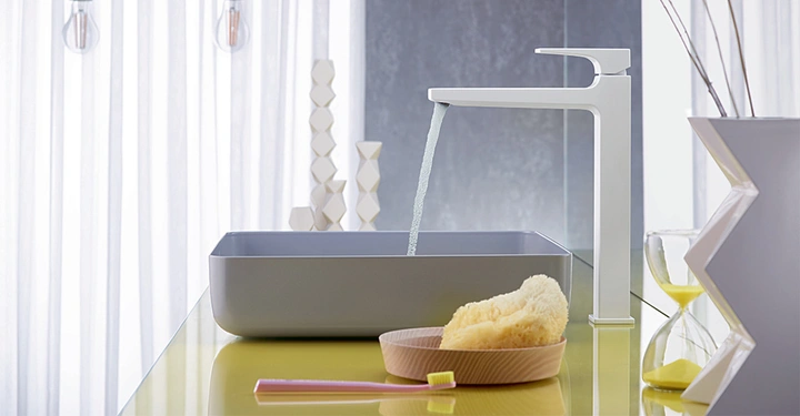 Wasserhahn fließt in rechteckiges Waschbecken moderne Badezimmerumgebung mit gelber Ablagevase mit Zweigen Bürste und Schwamm daneben weiße Vorhänge im Hintergrund