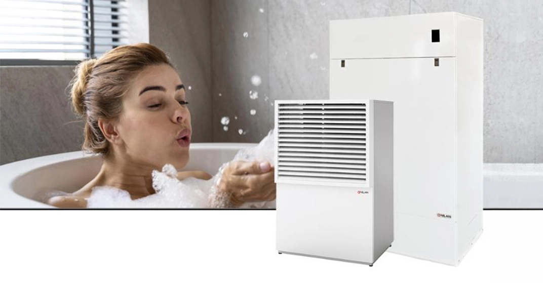 Frau in Badewanne bläst Badeschaum von Händen. Im Vordergrund Freisteller von DHW AIR9 Wärmepumpensystem.