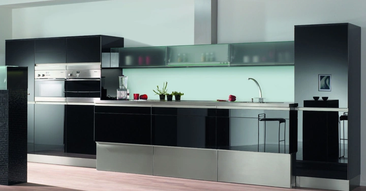 Galerie-Bild 3: Moderne schwarze Küche mit Hochglanzschränken und integrierten Geräten. Ein Wasserhahn mit Becken. Dekorative Pflanzen und Küchenutensilien stehen auf der Arbeitsfläche. Heller Raum mit Holzfußboden.