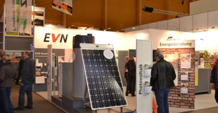 Galerie-Bild 29: Solarmodul ausgestellt in einer Messehalle Menschen besichtigen die Stände umgeben von Informationsschildern Text Energieberatung Photovoltaik EVN