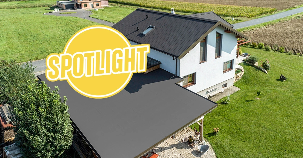 Einfamilienhäuser von oben mit Bramac-Dach gedeckt stehen auf grüner Wiese in der Sonne