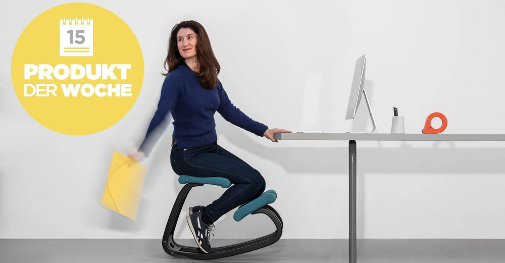 Frau sitzt auf einem ergonomischen Stuhl hält gelben Ordner in der Hand arbeitet an einem Schreibtisch mit einem Computer im modernen Büro. Text PRODUKT DER WOCHE Kalenderblatt mit der Zahl 15