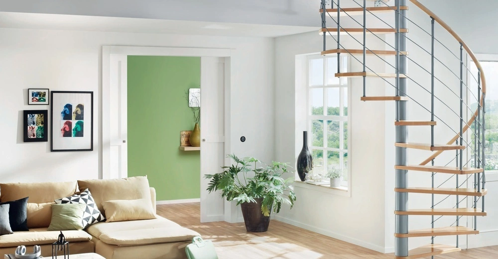 Spindeltreppe Caparo mit Massivholzstufen aus Buche, helles offenes Wohnzimmer mit Couch und Laminatboden