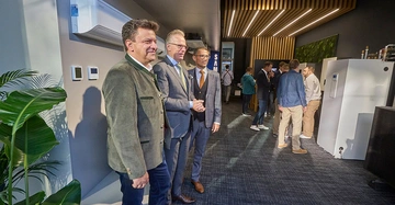 perspektivische Aufnahme von drei Männern bei der Eröffnung des Samsung Showrooms im Bauzentrum der Blauen Lagune.