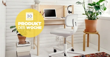 Ein weißer Bürostuhl steht vor einem kleinen Holzschreibtisch mit einem Laptop und Kopfhörern darauf in einem hellen Zimmer mit Pflanzen Text PRODUKT DER WOCHE und Kalender 30