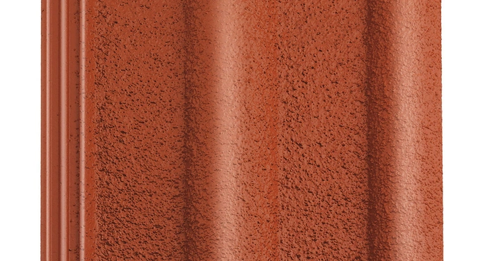 Rote Dachziegelplatte liegt flach. Sie hat eine strukturierte Oberfläche und wellenförmige Erhebungen. Umgebung ist nicht erkennbar.