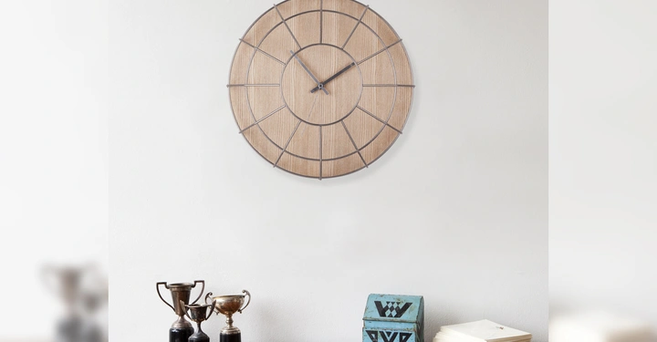 Galerie-Bild 3: Holzuhr hängt an Wand drei Trophäen stehen auf Holztisch daneben sind eine blaue dekorative Kiste und ein Stapel Papiere in einem spärlich eingerichteten Raum