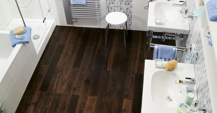 Galerie-Bild 3: Zwei Waschbecken stehen nebeneinander in einem mit Fliesen verkleideten Badezimmer während ein Hocker vor einem Handtuchwärmer steht. Ein Föhn liegt auf einem der Waschbecken.