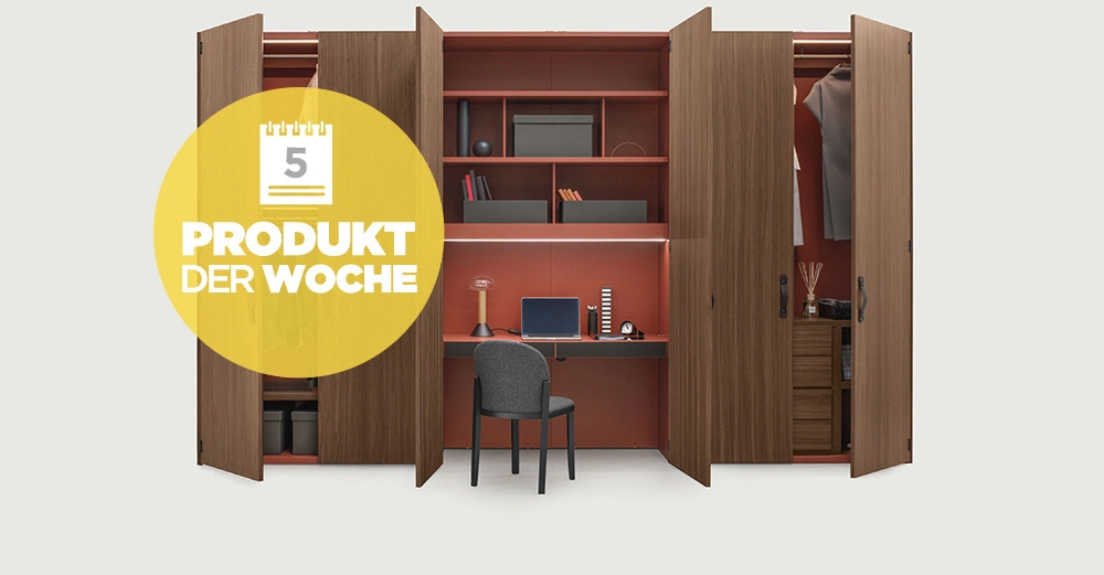 Holzschrank offen mit Arbeitsstation und Regalen darin Stuhl steht vor dem Schreibtisch An den Schranktüren hängen Kleider und darüber steht in einem gelben Kreis Text PROUKT DER WOCHE