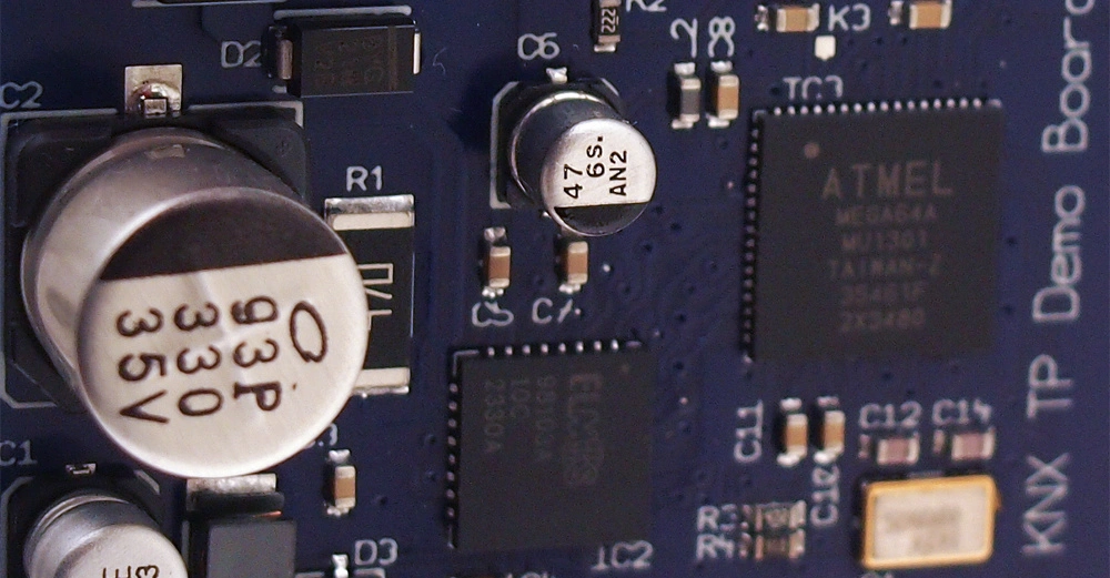 Leiterplatte mit mehreren elektronischen Komponenten wie Kondensatoren und ICs die miteinander verbunden sind Text umfassen 93P 330 35V 22 35E 1C3 47 6S AN2 ATmel MEGA48A MU301 TAIWAN 2207 SMD 21480 KNX TP Board Lightning Actuator Push Button Sensor Temperature