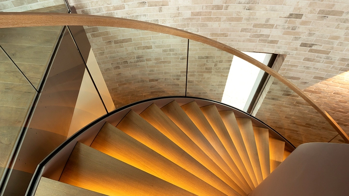 Galerie-Bild 3: Blick auf eine Wendeltreppe mit Holzstufen und indirekter Beleuchtung