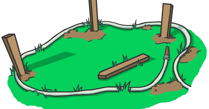 Vier Holzpfähle stehen im Gras, verbunden durch einen Schlauch in einem unregelmäßigen Kreis und einen einzelnen Holzstab liegt daneben.