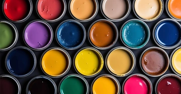 Flatlay von verschiedenen offenen Farbkübeln mit Wandfarbe in unterschiedlichen Farben.