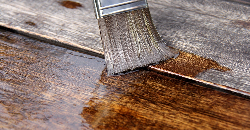 Pinsel trägt Lack auf Holzoberfläche auf Holzbretter im Hintergrund Text auf dem Pinselgriff 50
