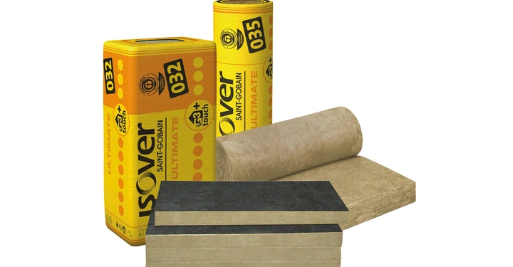 Gelbe Verpackungen mit der Aufschrift ISOVER SAINT-GOBAIN 032 und 035 stehen nebeneinander; davor liegen ein ausgerolltes Dämmstoff-Bündel und vier Dämmstoffplatten auf einem Stapel.