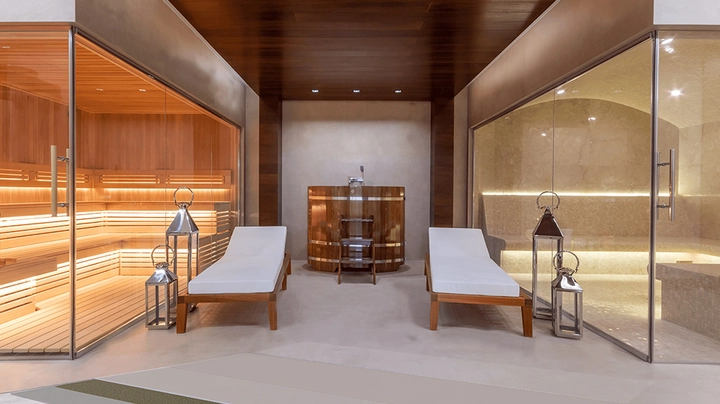 öffentlicher Wellnessbereich mit Sauna und Dampfbad, zwei Liegen und großer Wanne in der Mitte