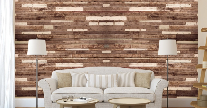 Ein cremefarbenes Sofa steht vor einer Holzwand im Wohnzimmer mit zwei stehenden Lampen an den Seiten und einem runden Couchtisch mit Büchern und Gläsern darauf.