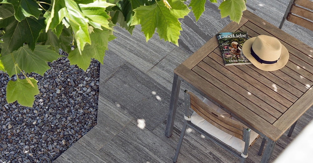 Die markanten Strukturen der Terrassenplatten aus Granit Urban Grey Line eigenen sich perfekt für den modernen, reduzierten Außenbereich. Was Granit besonders macht: seine schöne Tiefenstruktur, die sich durch Einschlüsse und feine Aderungen ergeben, sowie seine samtige Haptik!&nbsp;