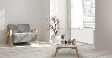 Ein minimalistisch stilvoll eingerichtetes Zimmer, das mit einem Heizkörper + Wärmepumpe von VOGEL&NOOT gewärmt wird.