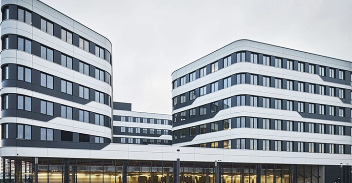 Großaufnahme des Skoda Hauptquartiers in Tchechien, stark bewölkter, grauweißer Himmel, typisches Bürogebäude in weiß mit vielen Fenstern