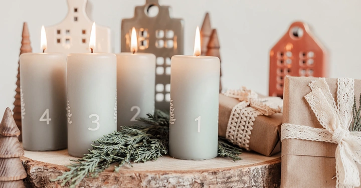 Moderner Adventskranz im Skandi-Stil mit vier nummerierten Kerzen, im Vergleich zum ursprünglichen Wagenrad mit Kerzen für jeden Tag.