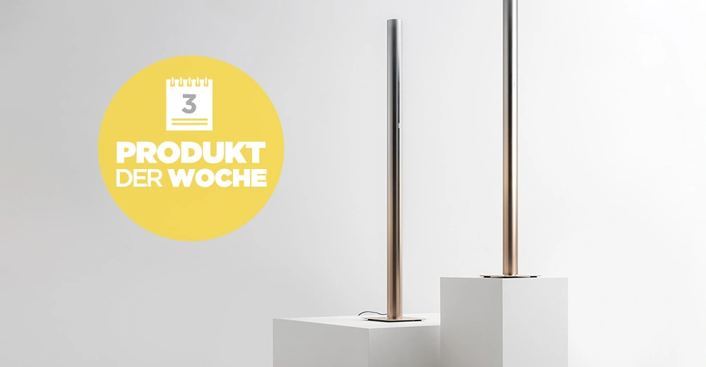 Zwei moderne Standlampen stehen auf weißen Podesten in einem minimalistischen Raum. Links daneben ein gelber Kreis mit einem Kalender und Text 3 PRODUKT DER WOCHE.