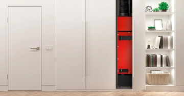 Lüftungsgerät HomeVent von Hoval mit rotem Gehäuse leuchtet hinter einer weißen Einbauschranktür hervor