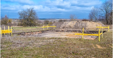 Planum für Bodenplatte mit gelben Absicherungszäunen vor blauem Himmel
