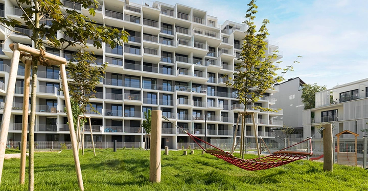 Aufnahme des Wohngebäudes Kennedy Garden von der BUWOG, im Vordergrund grüner Park und Kinderspielplatz