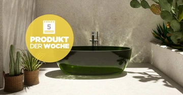 Eine glänzende grüne Badewanne steht auf einem hellen, schattigen Boden mit Pflanzen in Körben. Auf der linken Seite ist ein gelber Kreis mit der Aufschrift: "5 PRODUKT DER WOCHE".