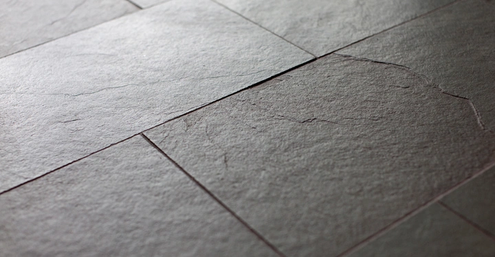 Galerie-Bild 10: Graue Fliesen liegen auf dem Boden mit einer strukturierten Oberfläche und leicht sichtbaren Fugen in einem Raum ohne weitere sichtbare Objekte oder Möbel