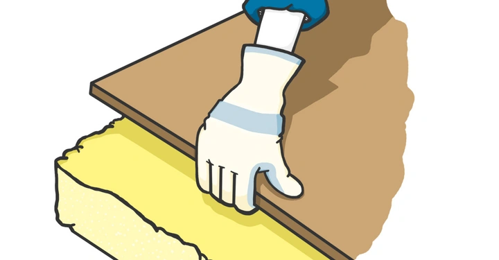 Hand in Handschuh hebt Holzplatte um gelbliches Isoliermaterial darunter freizulegen in Bastelumgebung