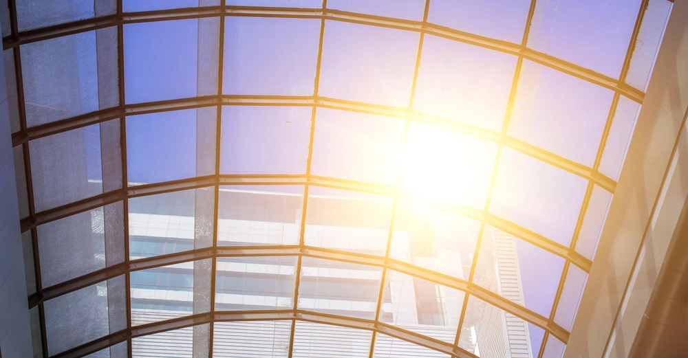 Gewölbtes Glasdach gefiltertes Sonnenlicht scheint durch Struktur modernes Bürogebäude im Hintergrund helle Umgebung