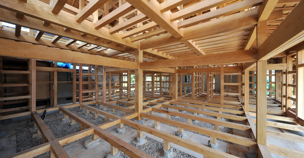 Rohbau aus Holz: großer Raum in Holzriegel-Bauweise auf Schüttung geständert, Blick in oberer Geschoße frei