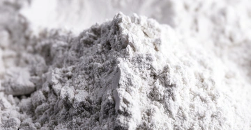 Ein Haufen weißes Pulver liegt auf einer Oberfläche in einem unscharfen Hintergrund