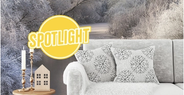 weiße Couch mit zwei Zierkissen steht vor wunderschöner Winterlandschaft