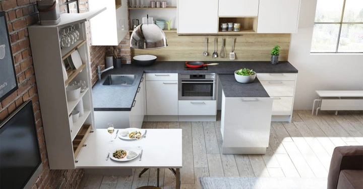 Küchentheke mit Gedeck für zwei Personen Milchglasvitrine und Küchenzeile mit weißen Schränken schwarze Arbeitsflächen Pfanne auf Herd Topfpflanze helle Wände und Bodenfliesen große Fenster backsteinverkleidete Wand links