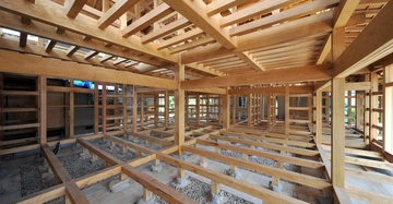 Rohbau aus Holz: großer Raum in Holzriegel-Bauweise auf Schüttung geständert, Blick in oberer Geschoße frei